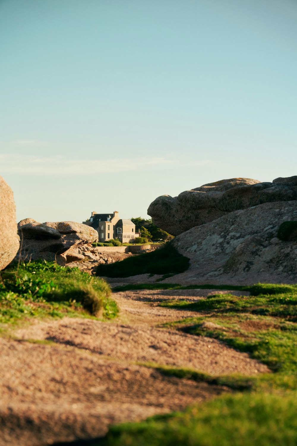 a large rock sitting on the side of a dirt road