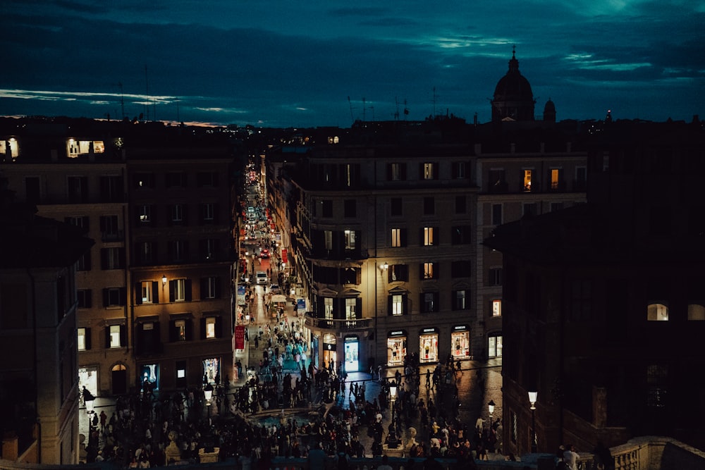 a crowd of people walking down a street at night