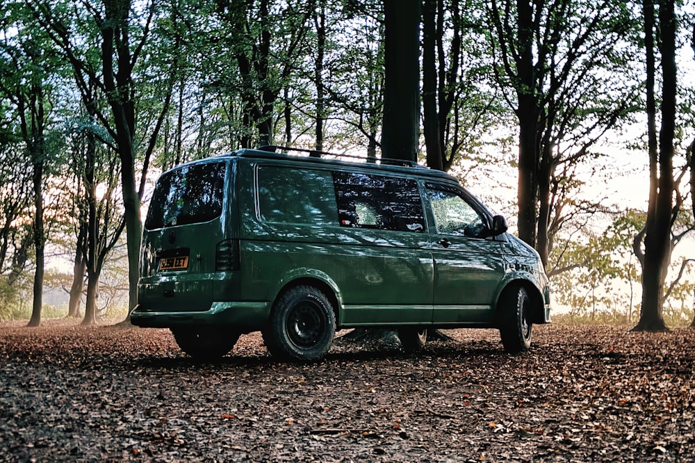 Uma van verde está estacionada na floresta