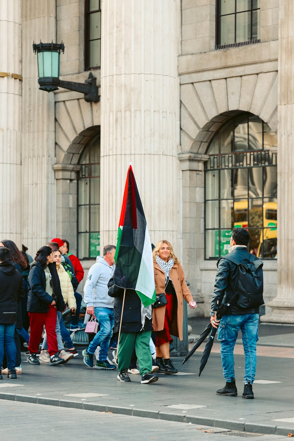 a group of people walking down a street holding flags