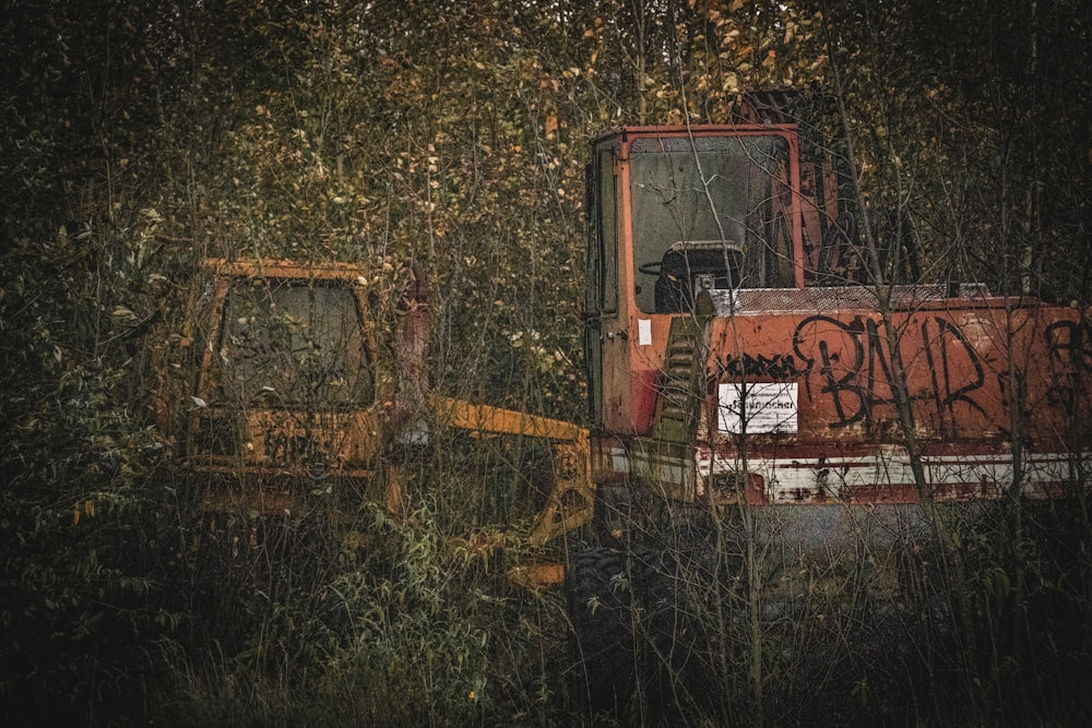 a rusted out truck sitting in the middle of a forest