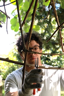 a man holding a pair of scissors in a tree