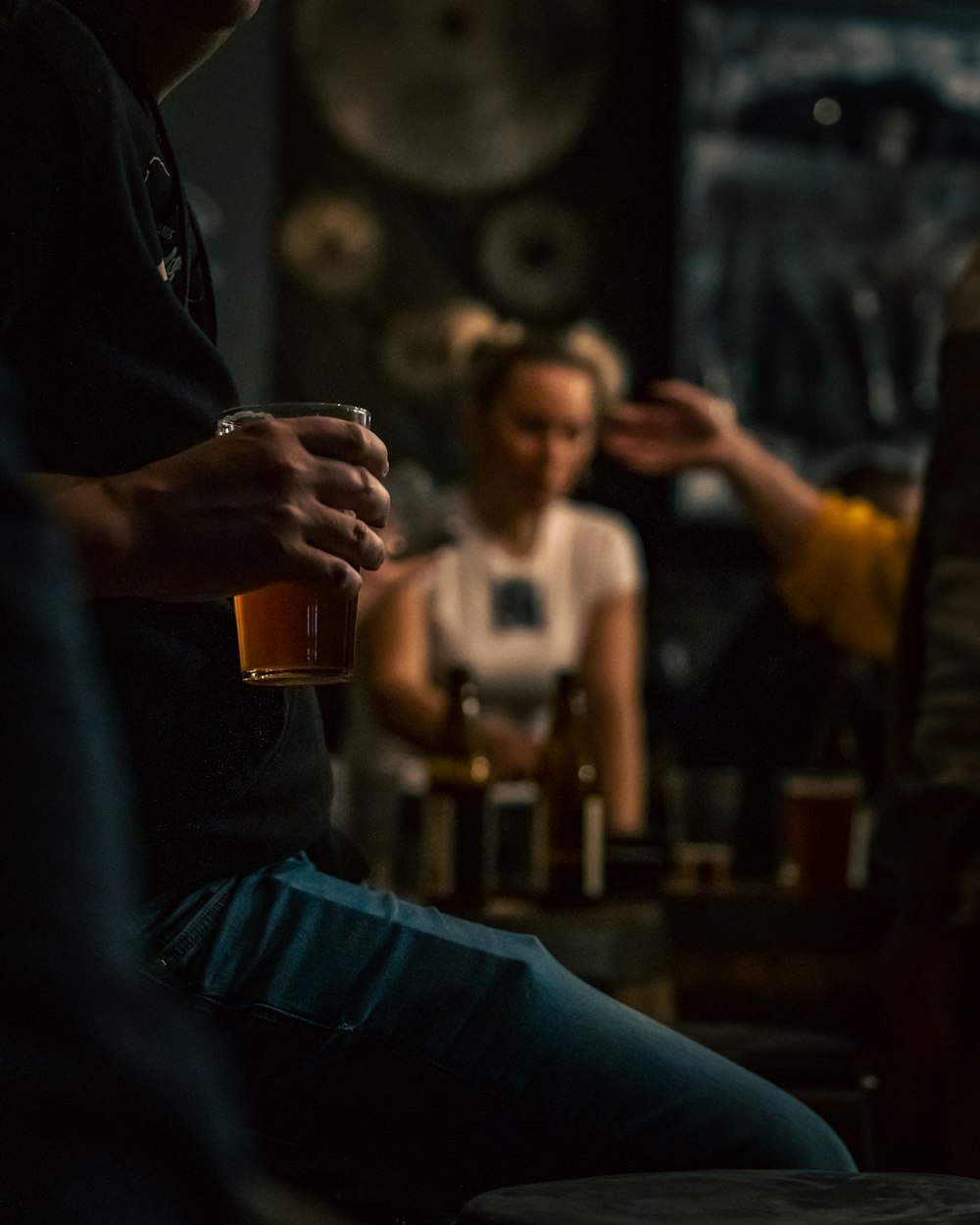 a man sitting in a bar holding a glass of beer