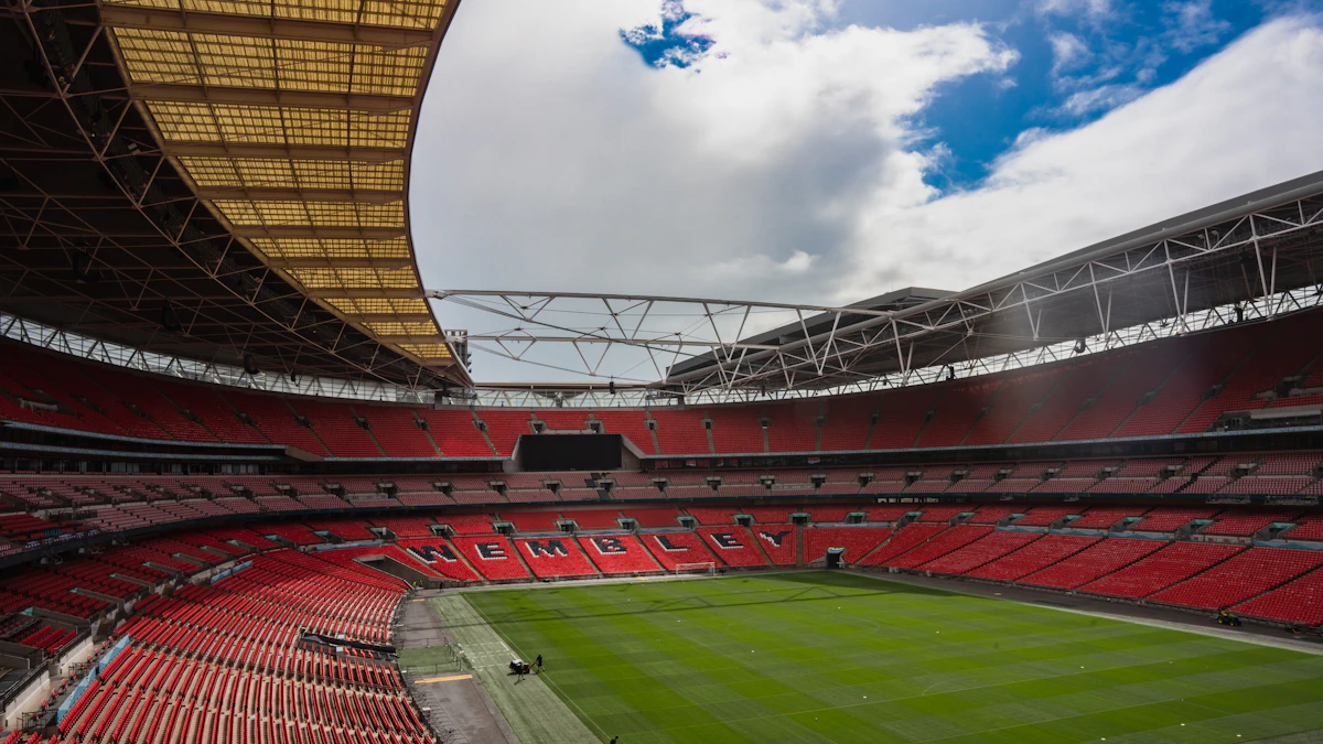 Green football pitch and red stands inside Wembley Stadium