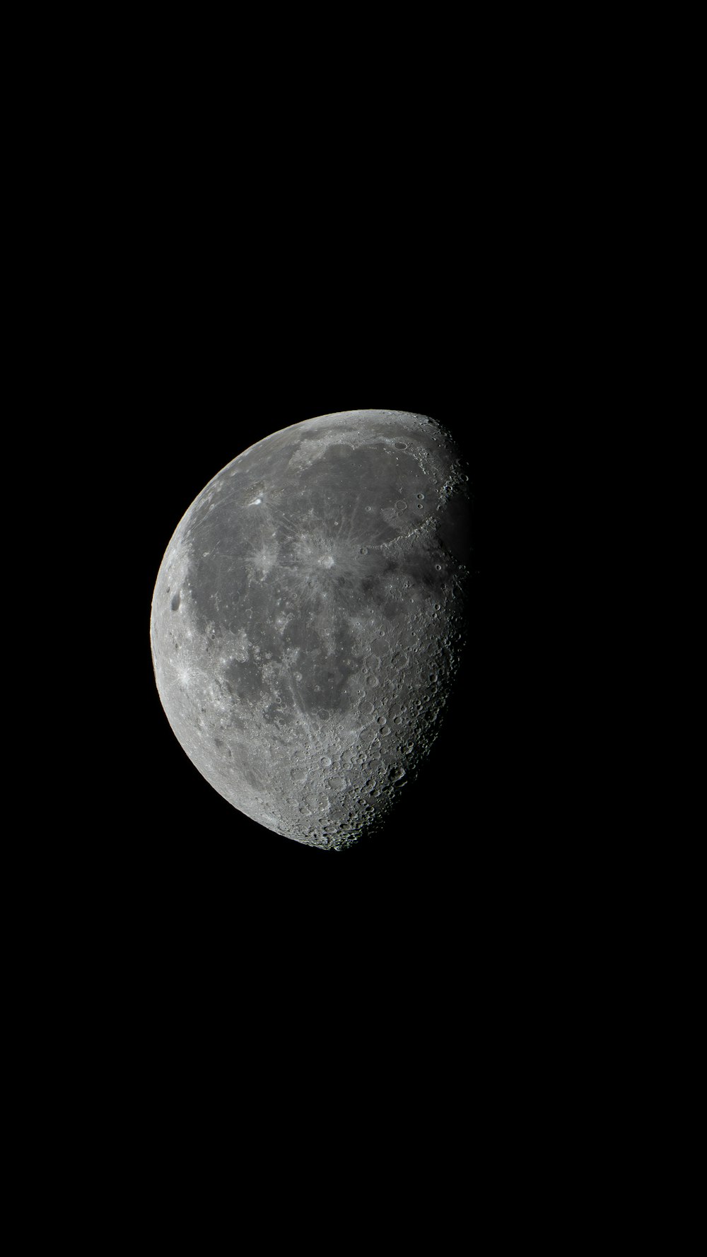 uma meia lua é vista no céu escuro