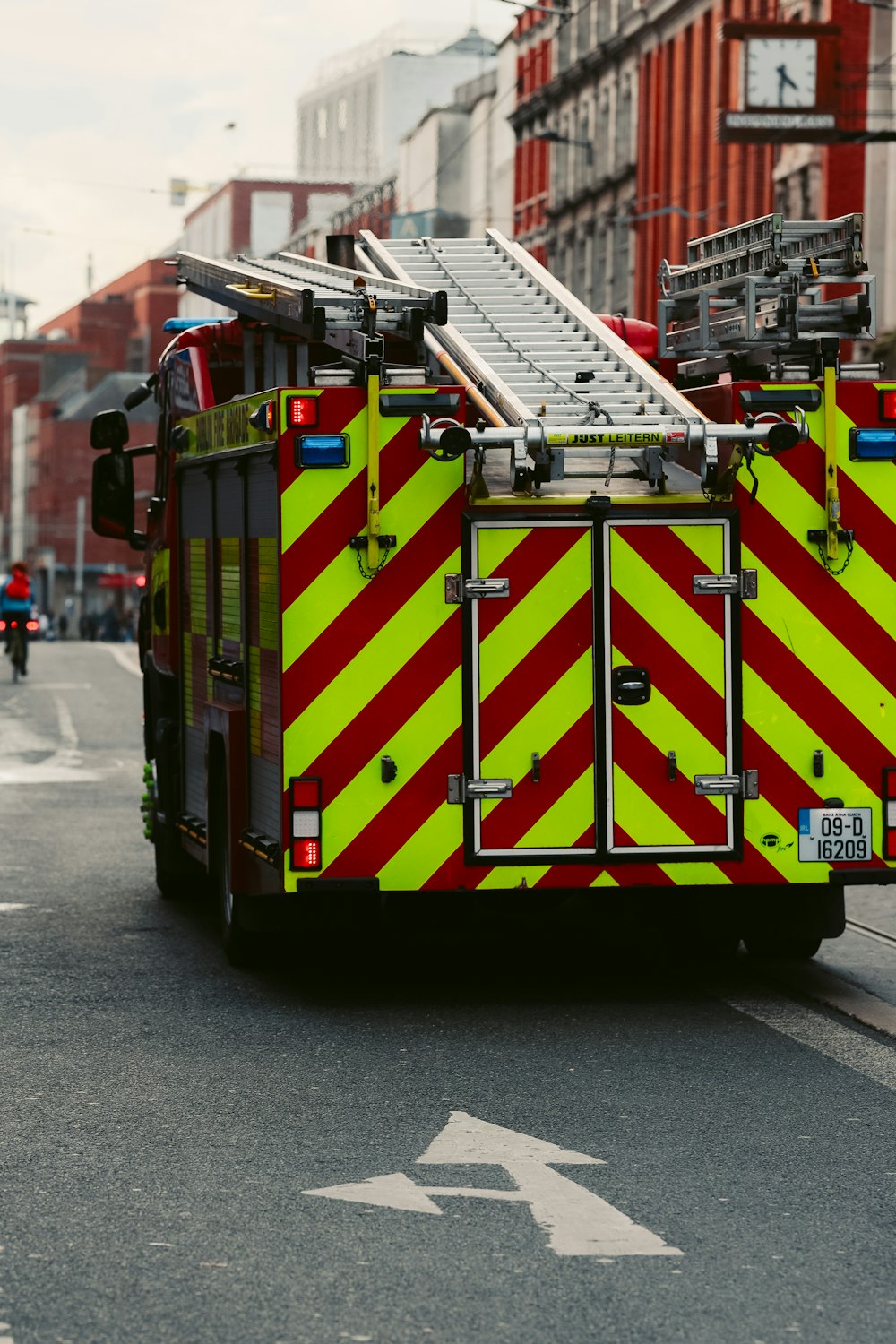 a fire truck driving down a street next to tall buildings