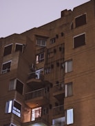 Nighttime photo showing lit-up multi-story apartment complex