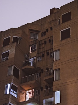 Nighttime photo showing lit-up multi-story apartment complex