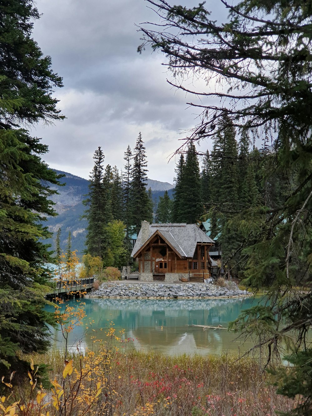 a cabin in the middle of a lake surrounded by trees