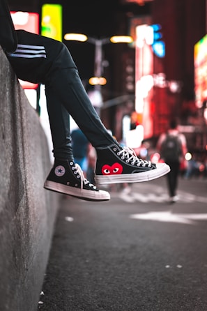 A pair of stylish Lumina Apparel sneakers resting on a concrete ledge with city skyline in background.