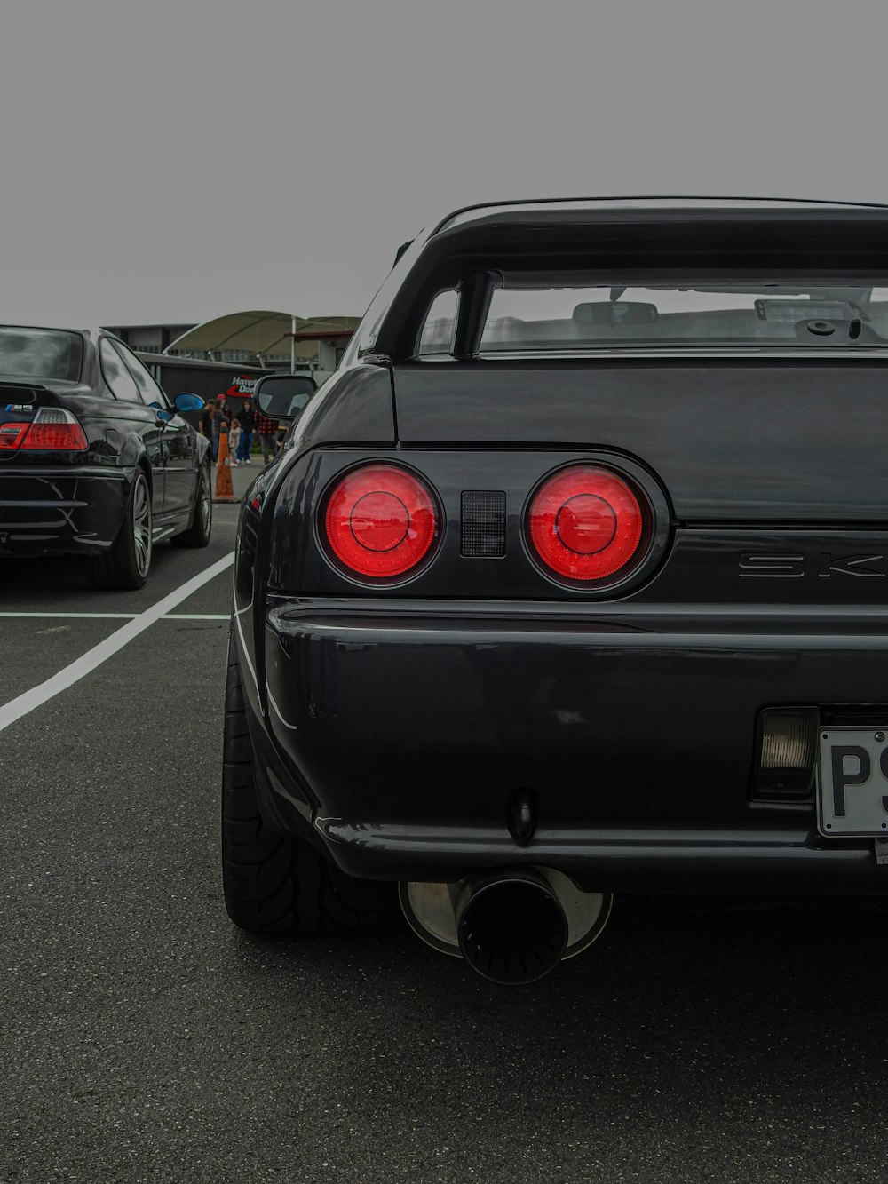 a black car parked in a parking lot next to other cars