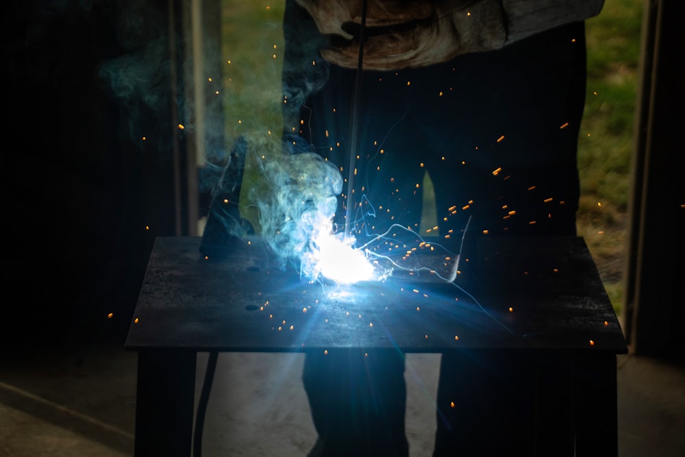 a person welding a piece of metal on a table