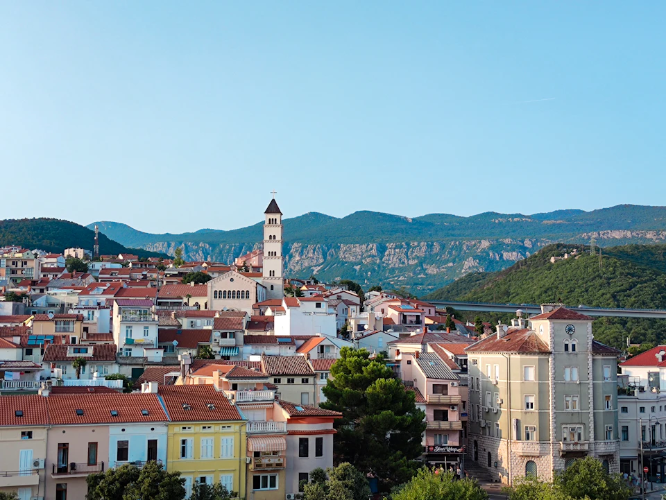 Terracotta rooftops and the church tower in Crikvenica, with the Vinodol hills beyond