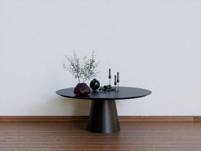a black table with two vases on top of it