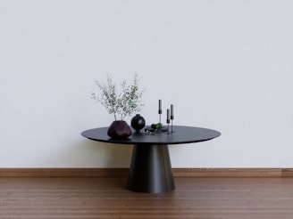 a black table with two vases on top of it