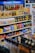 A well-organized supermarket shelf displaying a variety of snacks including cookies, crackers, and confectionery along with a prominent Pepsi logo at the top. The shelves are stocked with items like Milano cookies, Goldfish, Pringles, and Honey Bunches of Oats. The products are colorful, and the display is neatly arranged.