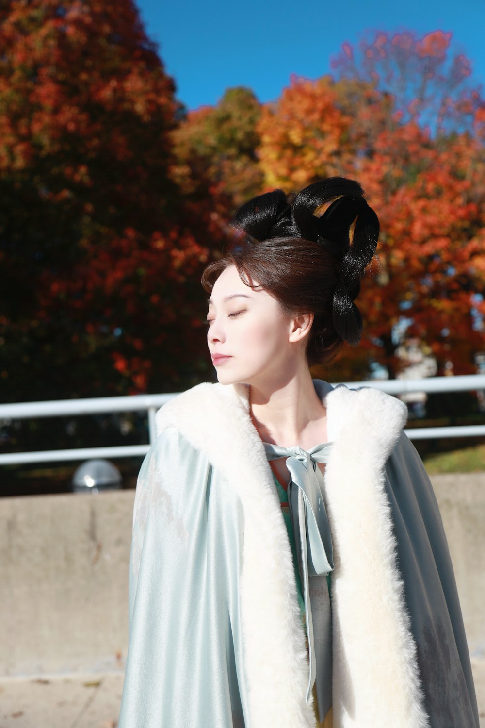 a woman in a blue dress and a fur coat