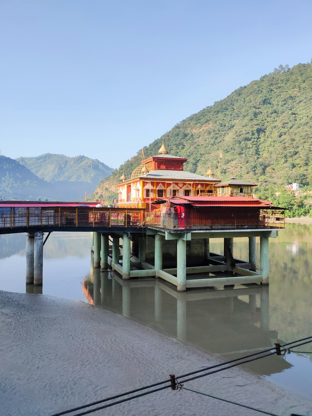 a bridge over a body of water with mountains in the background