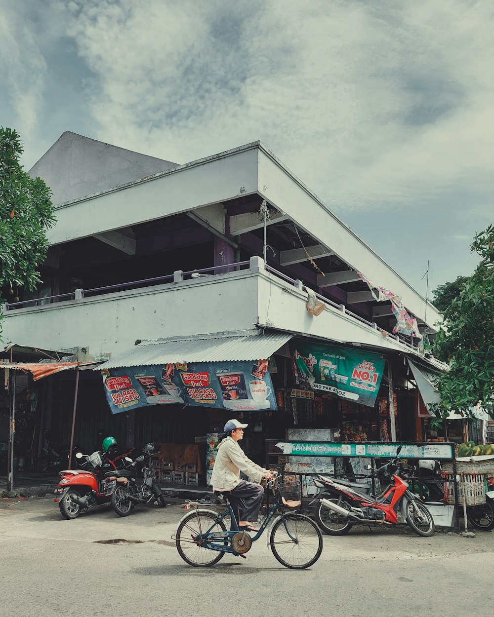 a man riding a bike down a street next to a tall building