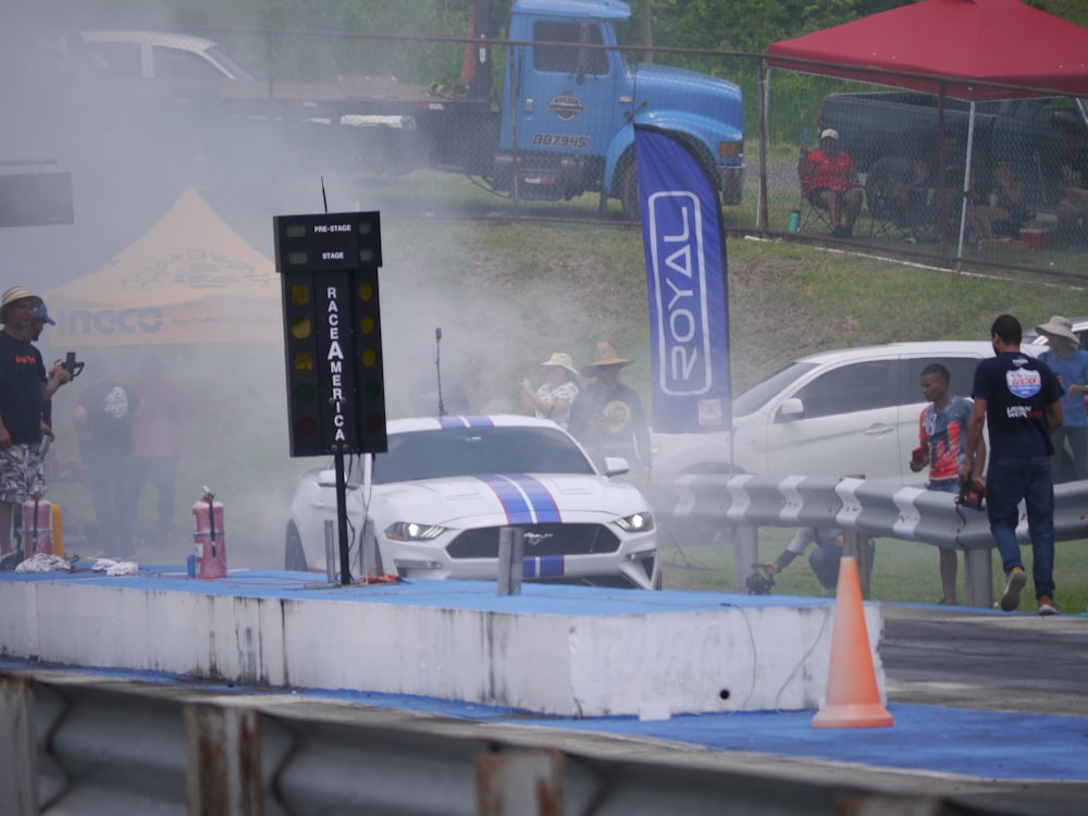 a group of people standing around a race track