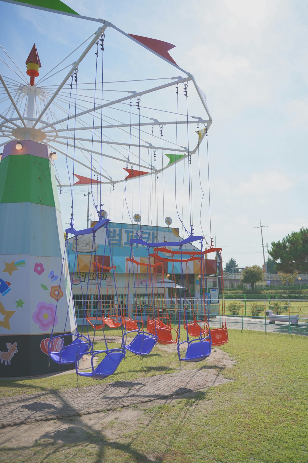 an amusement park with a ferris wheel and swings