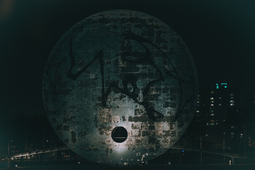 a large round object in the middle of a city at night