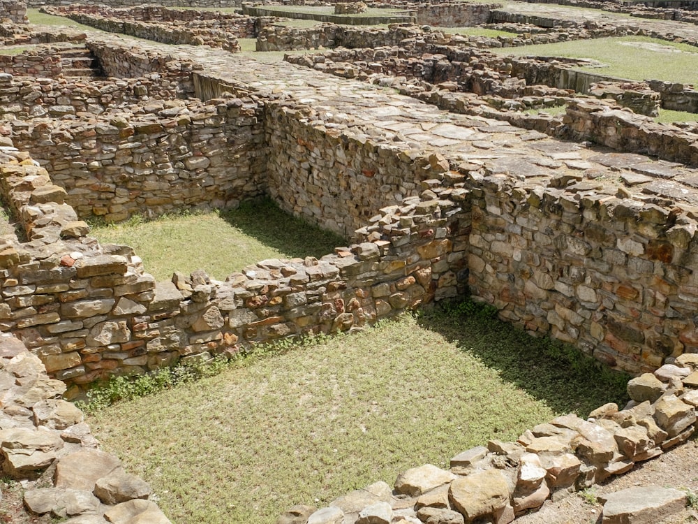 a stone building with grass in the middle of it