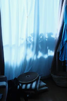 Elegant loungewear folded neatly beside a window framed by soft sage curtains.