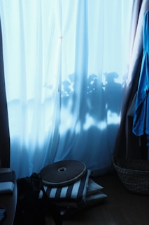 A serene studio corner with natural light highlighting a collection of handcrafted indigo garments