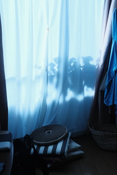 A cozy meditation room with floor cushions and soft natural light filtering through linen curtains.