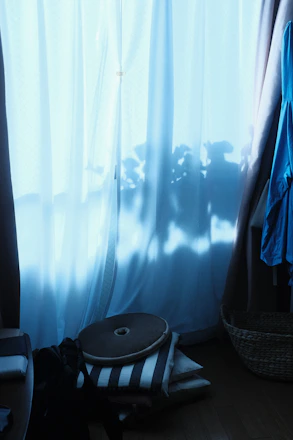 A serene pastel-toned room with soft cushions and a birthing ball, sunlight filtering through sheer curtains.