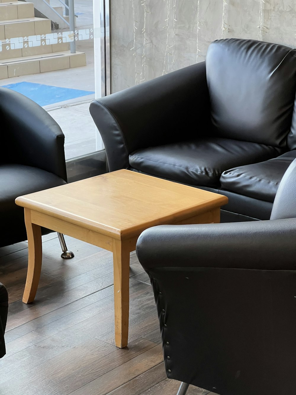 a living room with two black leather chairs and a coffee table