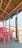 A rustic beachside setup with a wooden structure featuring a thatched roof, overlooking the sea. Inside the structure, several red plastic chairs surround a table. The view extends out to the sandy beach and the ocean, creating a tranquil and scenic atmosphere.
