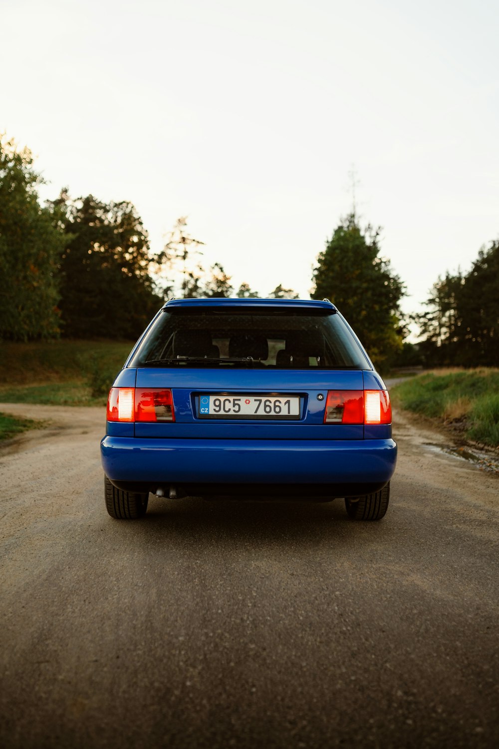 a blue car is parked on the side of the road