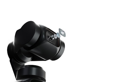 A robotic arm with a sleek, black design holds a series of lenses that appear to be suspended in mid-air. The background is a stark white, emphasizing the mechanical and sophisticated nature of the robotic technology.