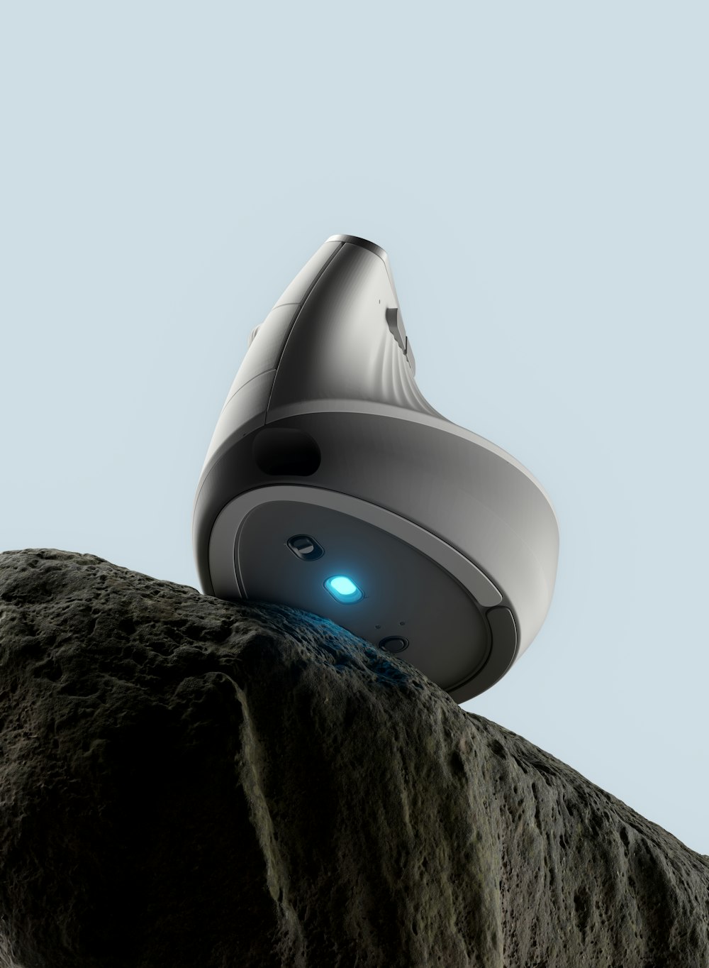 a robot sitting on top of a large rock
