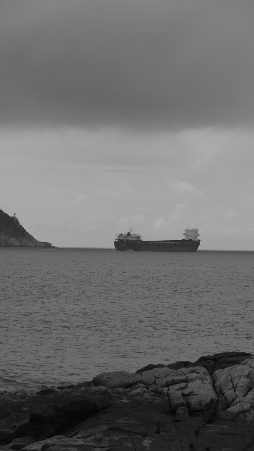 a large cargo ship in the distance on a cloudy day