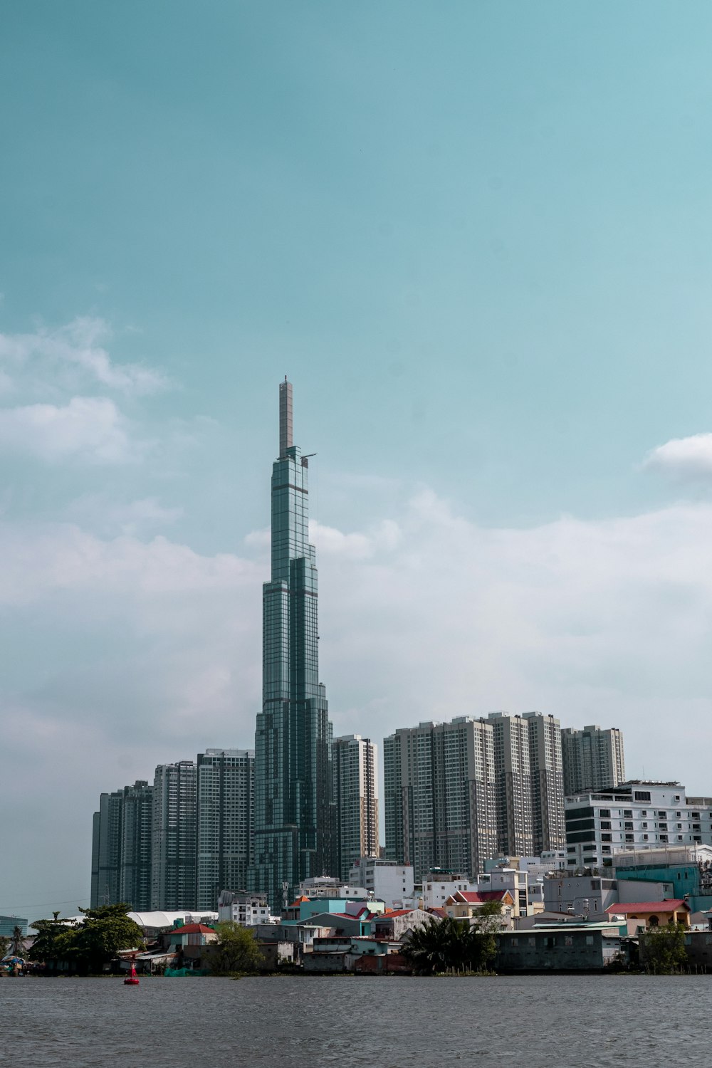 a tall building towering over a city next to a body of water