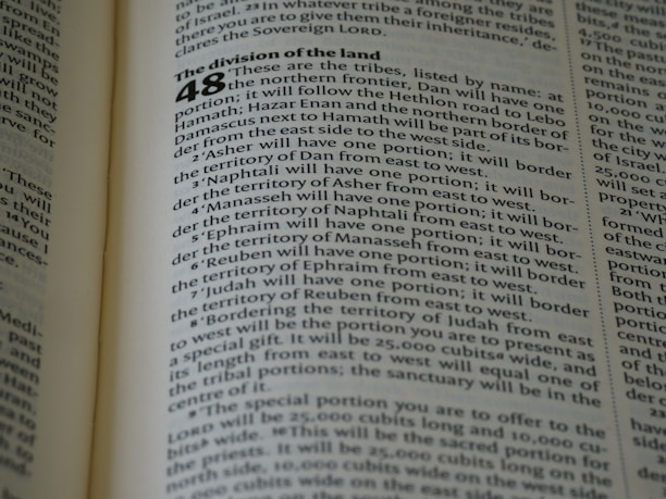 A close-up of an open book displaying a page with text. The layout is divided into sections with bold headings and numbered lists. The font is clear, and the lines of text are closely spaced. The lighting highlights the text, making it easy to read.