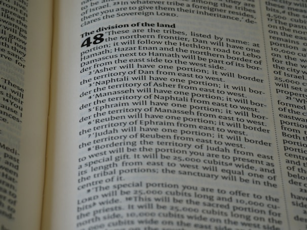 A close-up of an open book displaying a page with text. The layout is divided into sections with bold headings and numbered lists. The font is clear, and the lines of text are closely spaced. The lighting highlights the text, making it easy to read.