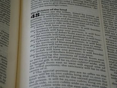 A close-up of an open book displaying a page with text. The layout is divided into sections with bold headings and numbered lists. The font is clear, and the lines of text are closely spaced. The lighting highlights the text, making it easy to read.
