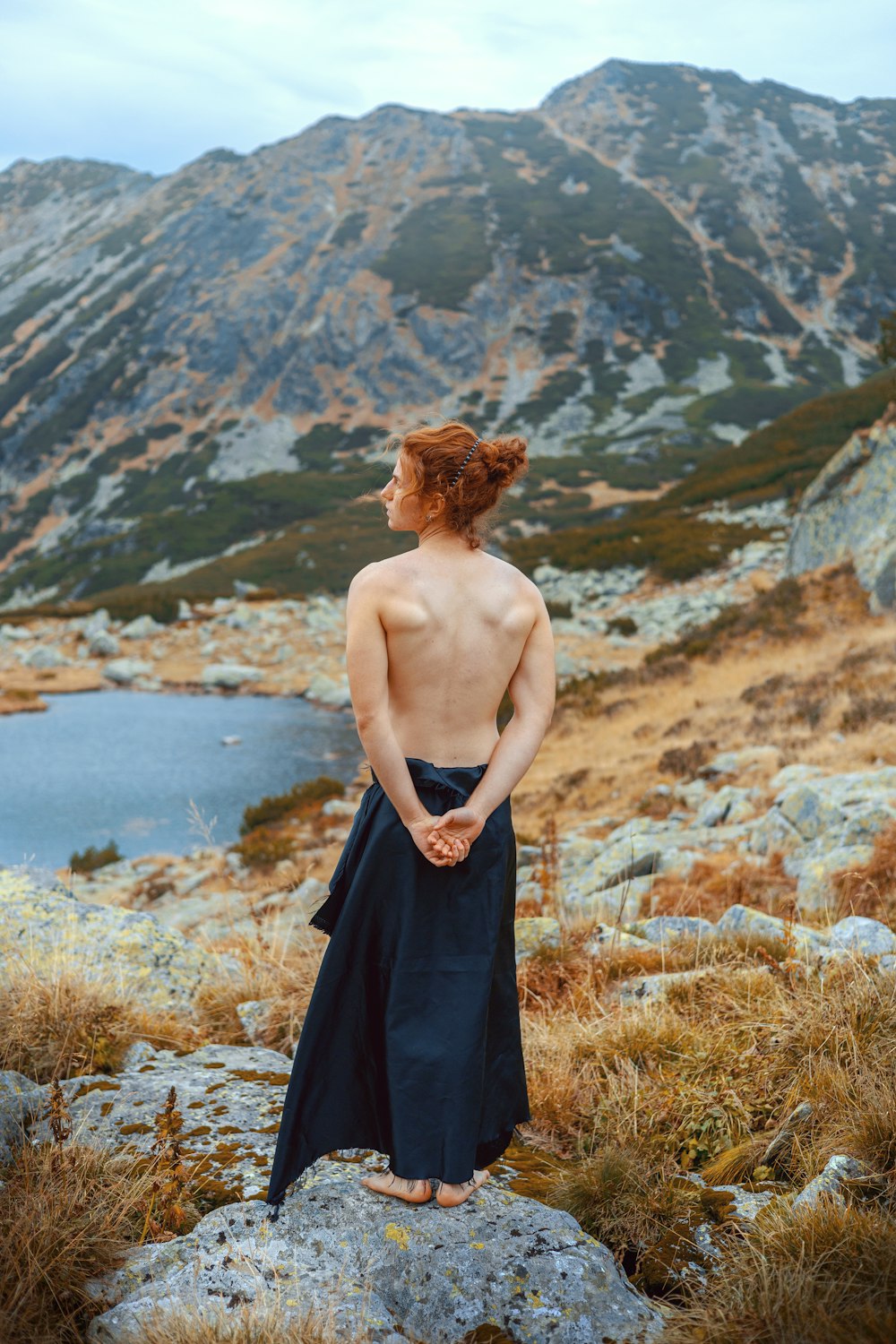 a shirtless man standing on top of a mountain