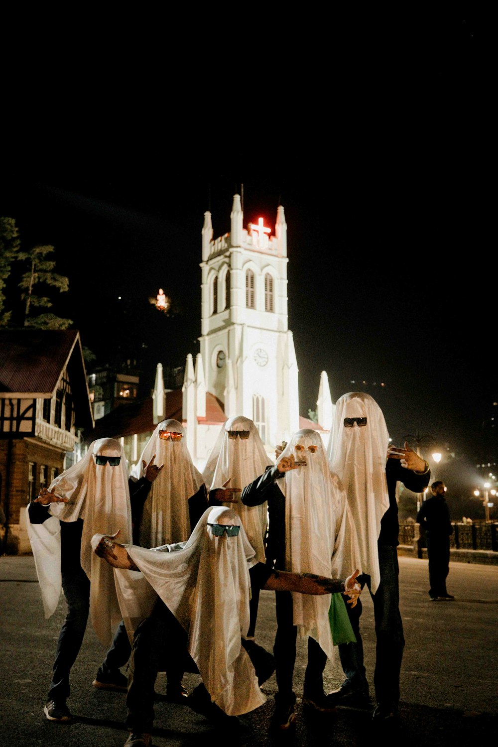 a group of people dressed in white standing in front of a church