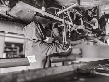 A mechanic installing a heavy-duty damper on a truck.