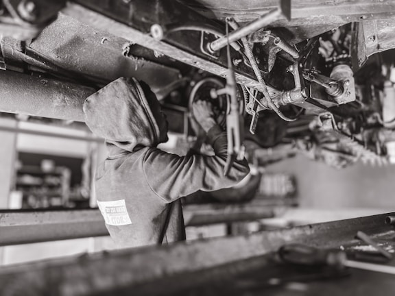 A mechanic inspecting a vehicle in a workshop.
