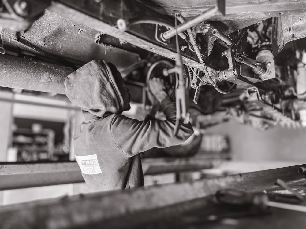 a man in a hoodie working on a machine