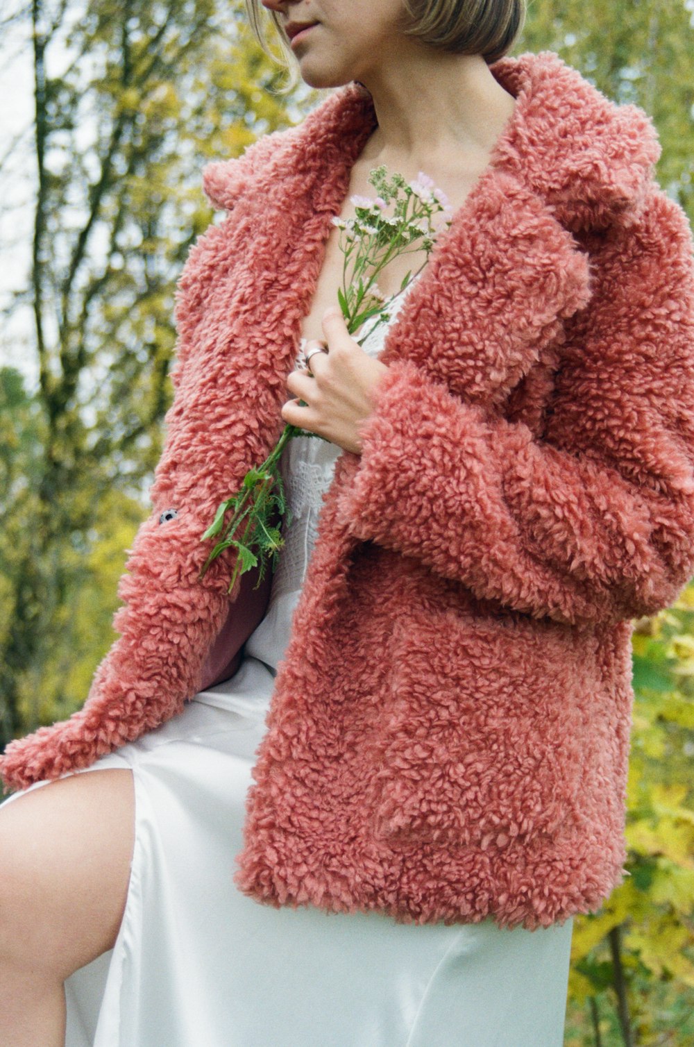 a woman in a white dress and a pink coat