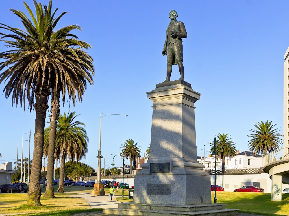 une statue d’un homme debout au milieu d’un parc