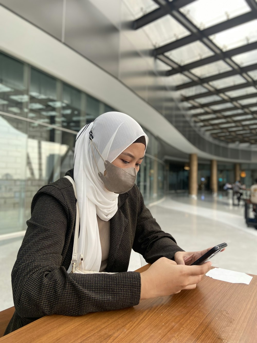 a woman sitting at a table using a cell phone