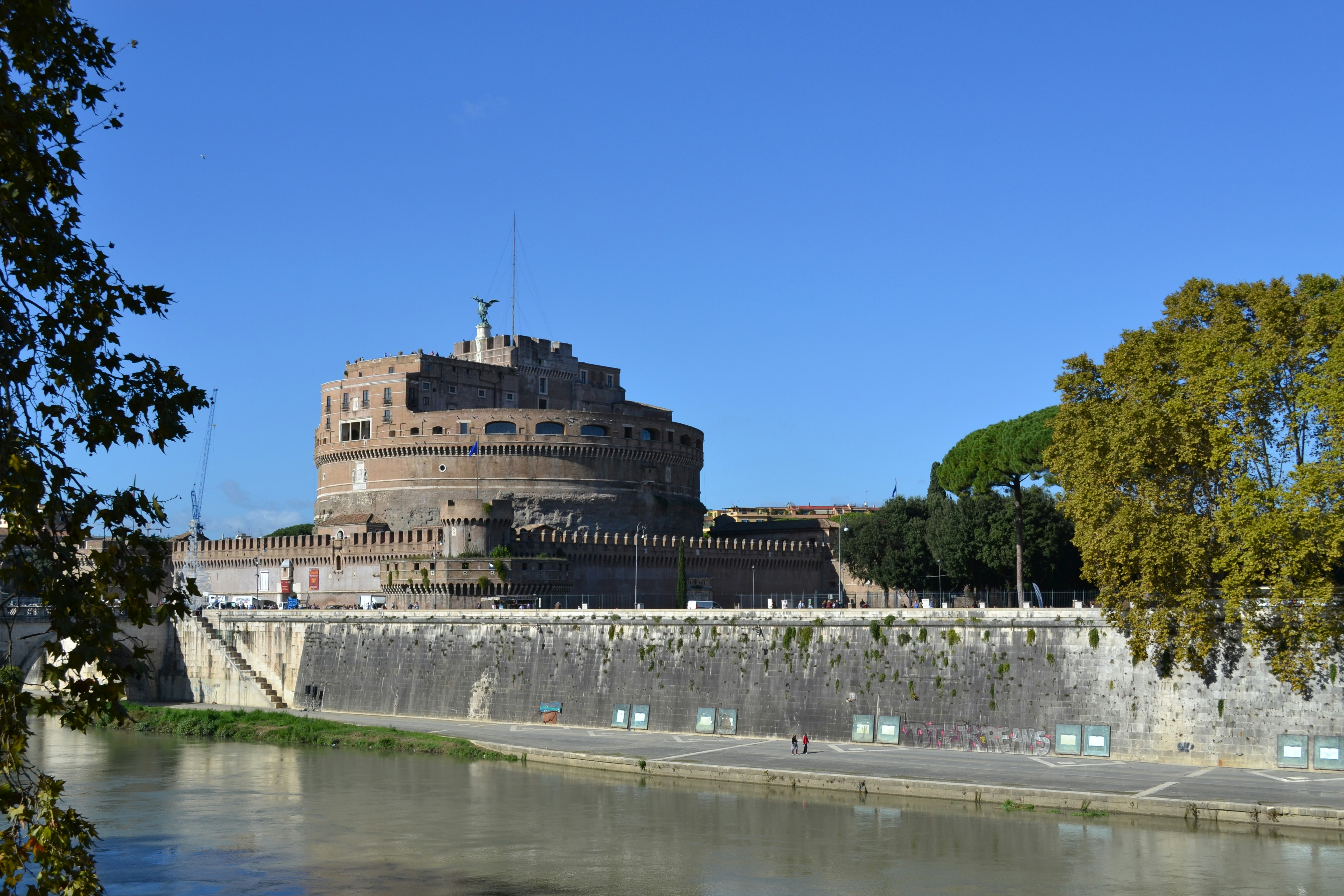 a large castle sitting on top of a hill next to a river